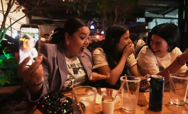 Fans gather to celebrate the release of Taylor Swift's new album, "The Life of a Showgirl" in Mexico City, Thursday, Oct. 2, 2025. (AP Photo/Claudia Rosel)