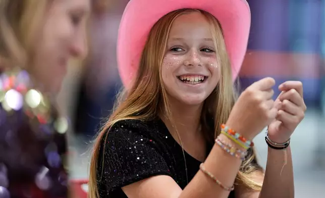 Hazel Gilbert, 10, builds a friendship bracelet during a release party for Taylor Swift's new album, "The Life of a Showgirl," at a movie theater Friday, Oct. 3, 2025, in Nashville, Tenn. (AP Photo/George Walker IV)