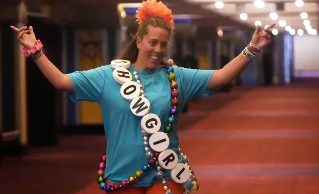Aimee Jay gestures walks towards her daughters before the official release of Taylor Swift's new album, "The Life of a Showgirl," at the AMC Metreon in San Francisco, Friday, Oct. 3, 2025. (AP Photo/Jeff Chiu)