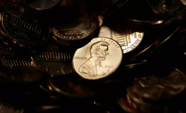 FILE - A lone penny is illuminated in a bin of completed pennies at the U.S. Mint in Denver on Aug. 15, 2007. (AP Photo/David Zalubowski, File)