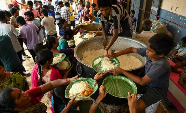 Evacuated Indian villagers of Uppada collect food to eat in a temporary relief centre as Cyclone Montha, in Kakinada district of Andhra Pradesh, India, Tuesday, Oct. 28, 2025. (AP Photo)