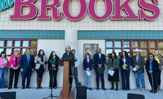 New Mexico Gov. Michelle Lujan Grisham, center, is flanked by state lawmakers as she announces the state will temporarily backfill SNAP benefits during a news conference outside a grocery store in Albuquerque, New Mexico, on Wednesday, Oct. 29, 2025. (AP Photo/Susan Montoya Bryan)
