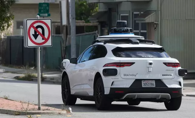 A Waymo vehicle drives past a No U-Turn sign in San Bruno, Calif., Tuesday, Sept. 30, 2025. (AP Photo/Jeff Chiu)