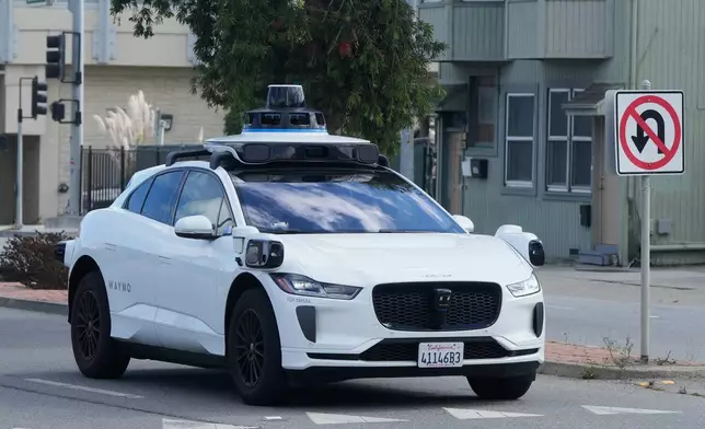 A Waymo vehicle drives past a No U-Turn sign in San Bruno, Calif., Tuesday, Sept. 30, 2025. (AP Photo/Jeff Chiu)