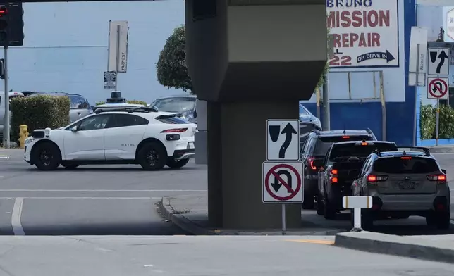 A Waymo vehicle makes a left turn in San Bruno, Calif., Tuesday, Sept. 30, 2025. (AP Photo/Jeff Chiu)