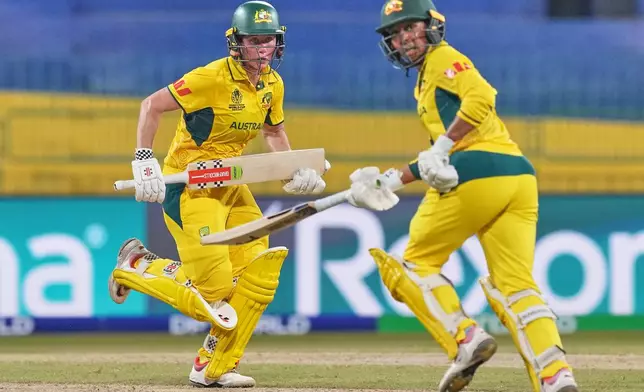 Australia's Beth Mooney, left, and Alana King run between the wickets to score during the ICC Women's Cricket World Cup match between Australia and Pakistan at Premadasa Stadium in Colombo, Sri Lanka, Wednesday, Oct, 8, 2025. (AP Photo/Eranga Jayawardena)