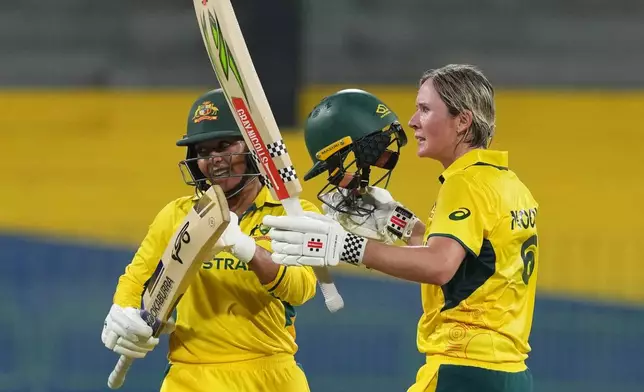 Australia's Beth Mooney, right, celebrates her as Alana King watches during the ICC Women's Cricket World Cup match between Australia and Pakistan at Premadasa Stadium in Colombo, Sri Lanka, Wednesday, Oct, 8, 2025. (AP Photo/Eranga Jayawardena)