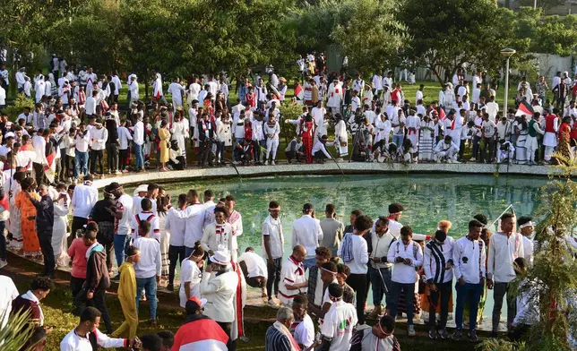 FILE - People throw grass and flowers into a pool of water as they celebrate the annual Irreecha festival in the capital Addis Ababa, Ethiopia, Oct. 1, 2022. (AP Photo/File)