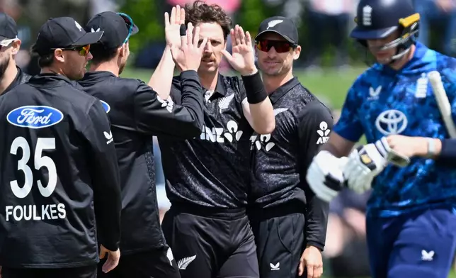 New Zealand bowler Matt Henry, centre, celebrates with teammates after taking the wicket of England batsman Jamie Smith during the One Day international cricket match between New Zealand and England in Mt Maunganui, New Zealand, Sunday, Oct.26, 2025. (Andrew Cornaga/Photosport via AP)