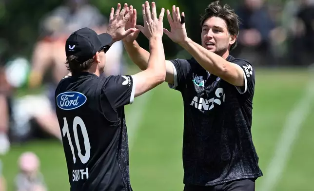 New Zealand bowler Zak Foulkes, right, celebrates after taking the wicket of England batsman Ben Duckett during the One Day international cricket match between New Zealand and England in Mt Maunganui, New Zealand, Sunday, Oct.26, 2025. (Andrew Cornaga/Photosport via AP)