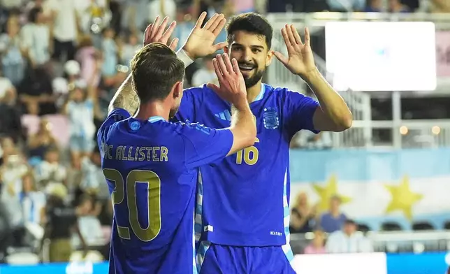 Argentina's Alexis Mac Allister (20) celebrates his goal with Flaco Lopez (16) during the first half of a friendly soccer match against Puerto Rico, Tuesday, Oct. 14, 2025, in Fort Lauderdale, Fla. (AP Photo/Marta Lavandier)