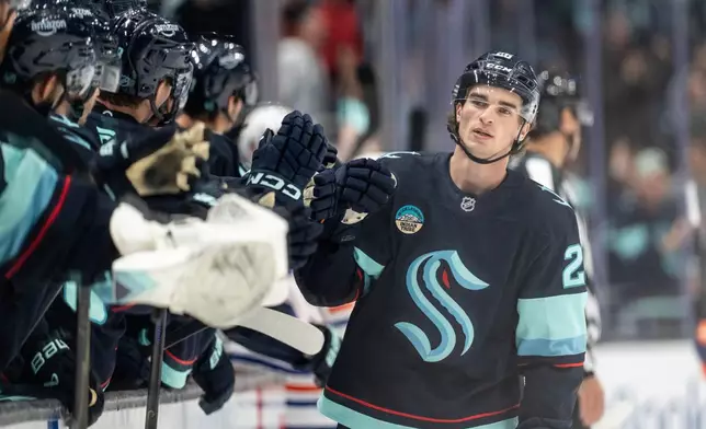 Seattle Kraken forward Ryan Winterton is congratulated by teammates on the bench after scoring a goal during the third period of an NHL preseason hockey game against the Edmonton Oilers, Wednesday, Oct. 1, 2025, in Seattle. (AP Photo/Stephen Brashear)