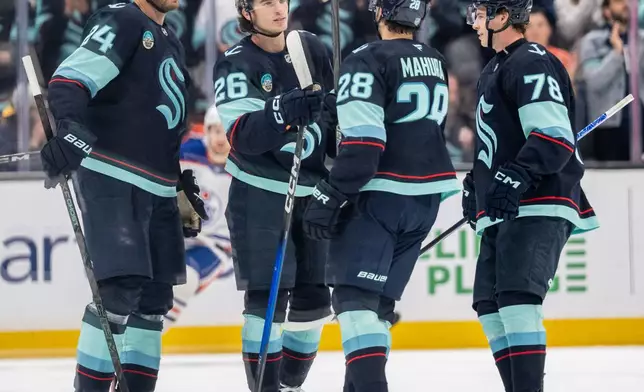 Seattle Kraken, from left, defenseman Jamie Oleksiak, forward Ryan Winterton, defenseman Joshua Mahura and forward Oscar Fisker Molgaard celebrate a goal during the first period of an NHL preseason hockey game against the Edmonton Oilers, Wednesday, Oct. 1, 2025, in Seattle. (AP Photo/Stephen Brashear)