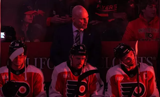 Philadelphia Flyers head coach Rick Tocchet, center top, looks on before an NHL hockey game against the Florida Panthers, Monday, Oct. 13, 2025, in Philadelphia. (AP Photo/Matt Rourke)