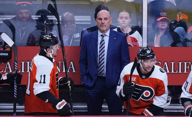 Philadelphia Flyers head coach Rick Tocchet, center, looks on from the bench during the first period of an NHL hockey game against the Florida Panthers, Monday, Oct. 13, 2025, in Philadelphia. (AP Photo/Matt Rourke)
