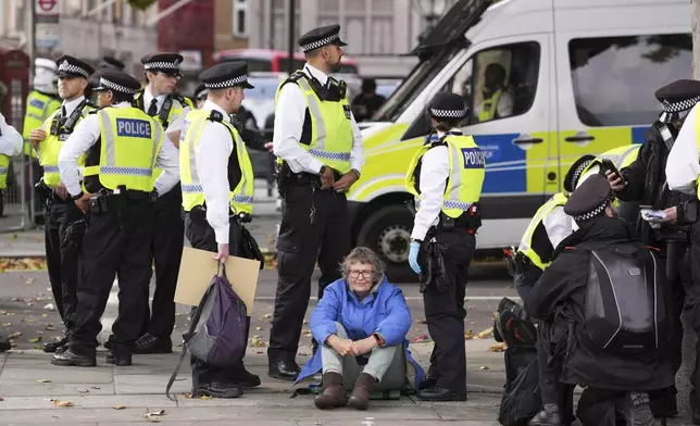 Police remove a protester taking part in a demonstration organised by Defend our Juries, in support of Palestine Action in Trafalgar Square, London Saturday Oct. 4, 2025. (Maja Smiejkowska/PA via AP)
