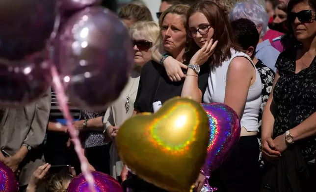 FILE - People hold a minute of silence in a square in central Manchester, England, on May 25, 2017, after a suicide bombing attack at an Ariana Grande concert at the Manchester Arena. (AP Photo/Emilio Morenatti, File)