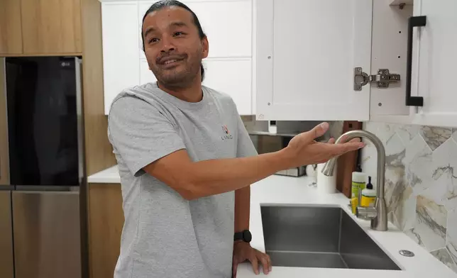 Josh Qian, co-founder of Linq Kitchen, a designer and maker of kitchen cabinets, shows kitchens made in Vietnam at a show room in City of Industry, Calif., Friday, Oct. 10, 2025. (AP Photo/Damian Dovarganes)