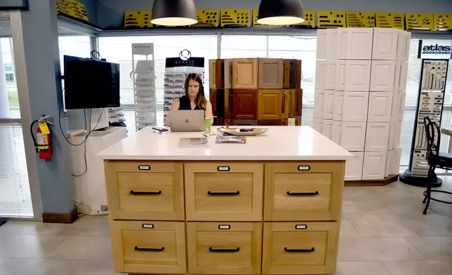 Andrea Mulkey, president and founder of Amish Cabinets of Denver, works in her showroom in Denver on Friday, Oct. 10, 2025. (AP Photo/Thomas Peipert)