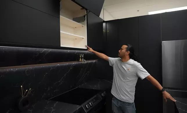 Josh Qian, co-founder of Linq Kitchen, a designer and maker of kitchen cabinets, shows his company's show room and warehouse in City of Industry, Calif., Friday, Oct. 10, 2025. (AP Photo/Damian Dovarganes)