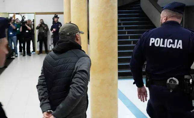 Ukrainian man who has been identified only as Volodymyr Z, center, who is suspected by German prosecutors of involvement in the 2022 attack on the Nord Stream gas pipelines leaves the courtroom of a regional court in Warsaw ,Poland, Friday, Oct. 17, 2025. (AP Photo/Czarek Sokolowski)