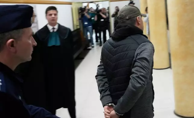 Ukrainian man who has been identified only as Volodymyr Z, right, who is suspected by German prosecutors of involvement in the 2022 attack on the Nord Stream gas pipelines leaves the courtroom of a regional court in Warsaw ,Poland, Friday, Oct. 17, 2025. (AP Photo/Czarek Sokolowski)