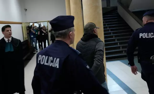 Ukrainian man who has been identified only as Volodymyr Z, second right, who is suspected by German prosecutors of involvement in the 2022 attack on the Nord Stream gas pipelines leaves the courtroom of a regional court in Warsaw ,Poland, Friday, Oct. 17, 2025. (AP Photo/Czarek Sokolowski)