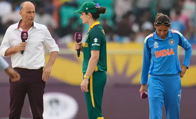 India's captain Harmanpreet Kaur, right, listens as South Africa's captain Laura Wolvaardt, center, speaks to the commentator Nasser Hussain at the toss ahead of the ICC Women's Cricket World Cup match between India and South Africa at ACA-VDCA Cricket Stadium in Visakhapatnam, India, Thursday, Oct. 9, 2025. (AP Photo/Aijaz Rahi)