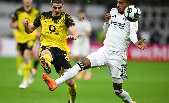 Frankfurt's Ansgar Knauff, right, and Dortmund's Marcel Sabitzer, left, challenge for the ballduring a German soccer cup second round match between Eintracht Frankfurt and Borussia Dortmund in Frankfurt, Germany, Tuesday, Oct. 28, 2025. (Arne Dedert/dpa via AP)