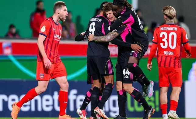 Center from left, Hamburg's Robert Glatzel, Luka Vuskovic and Jordan Torunarigha celebrate after a German soccer cup second round match between FC Heidenheim and Hamburger SV in Heidenheim, Germany, Tuesday, Oct. 28, 2025. (Tom Weller/dpa via AP)