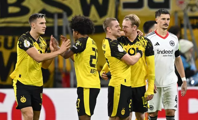 From left, Dortmund's Nico Schlotterbeck, Karim Adeyemi, Julian Ryerson and scorer Julian Brandt celebrate their side's first goal during a German soccer cup second round match between Eintracht Frankfurt and Borussia Dortmund in Frankfurt, Germany, Tuesday, Oct. 28, 2025. (Arne Dedert/dpa via AP)
