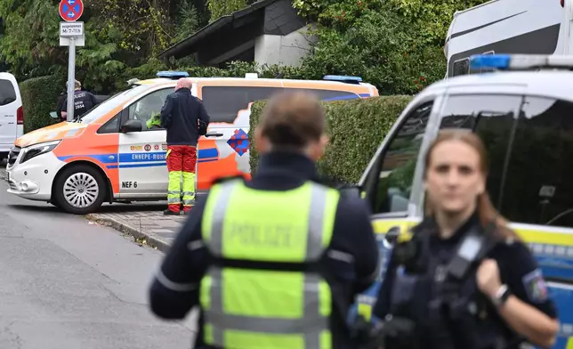 Police and emergency services stand on a street in Herdecke, Germany, Tuesday, Oct. 7, 2025, after the newly elected mayor of Herdecke, Iris Stalzer, has been found critically injured in her apartment. (Bernd Thissen/dpa via AP)