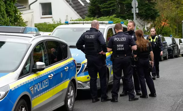 Police officers stand at a street in Herdecke, Germany, Tuesday, Oct. 7, 2025, after the newly elected mayor of Herdecke, Iris Stalzer, has been found critically injured in her apartment. (AP Photo/Martin Meissner)