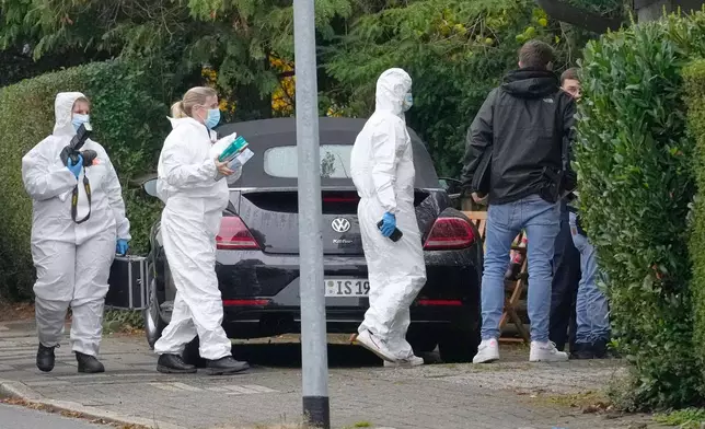 Forensic investigators appear at the crime scene at a street in Herdecke, Germany, Tuesday, Oct. 7, 2025, after the newly elected mayor of Herdecke, Iris Stalzer, has been found critically injured in her apartment. (AP Photo/Martin Meissner)
