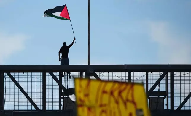 A pro-Palestinian demonstrator protests along the Rome's ring road as they gather for a national general strike called by different unions to protest against the situation in Gaza two days after Israeli forces intercepted a Gaza-bound aid flotilla in the Mediterranean Sea, in Rome, Friday, Oct. 3, 2025. (AP Photo/Alessandra Tarantino)
