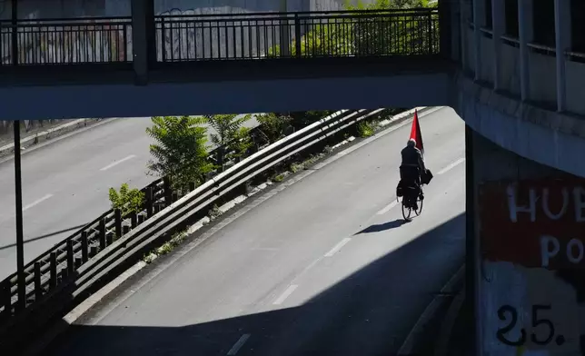 A pro-Palestinian demonstrator rides his bicycle along the Rome's ring road as he gathers for a national general strike called by different unions to protest against the situation in Gaza two days after Israeli forces intercepted a Gaza-bound aid flotilla in the Mediterranean Sea, in Rome, Friday, Oct. 3, 2025. (AP Photo/Alessandra Tarantino)