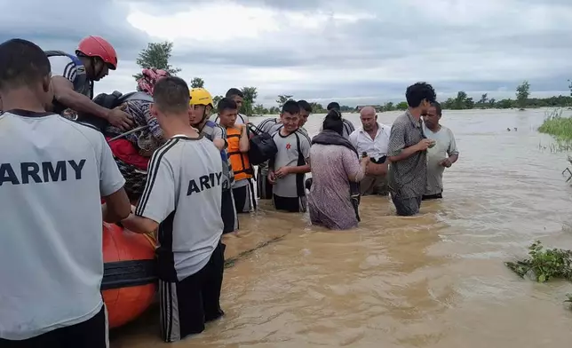 Nepalese army personnel transport survivors after a flood in Jhapa district east of Nepal, Sunday, Oct. 5, 2025. (Nepal Army via AP)