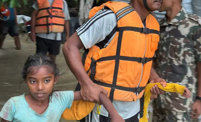 Nepalese army personnel rescue a child survivor following a flood in Jhapa district east of Nepal, Sunday, Oct. 5, 2025. (Nepal Army via AP)