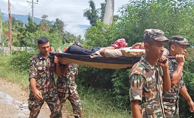 Nepalese army personnel carry a survivor from Nepal's eastern mountain district of Illam after landslides swept through the area in Illam, Nepal, Sunday, Oct. 5, 2025. (Nepal Army via AP)