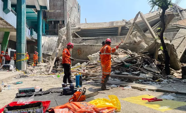 Rescuers spray disinfectant during the search for victims of a collapsed building at an Islamic boarding school in Sidoarjo, East Java, Indonesia, Friday, Oct. 3, 2025. (AP Photo/Trisnadi)