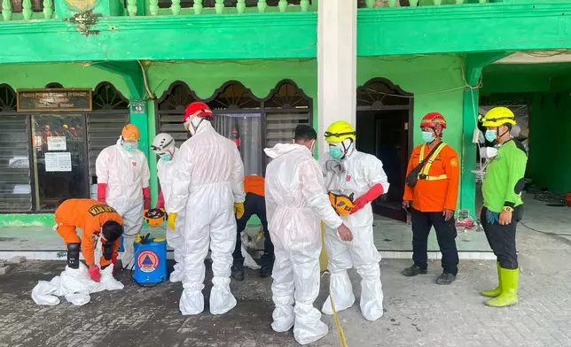 Rescuers don their protective suits during the search for victims of a collapsed building at an Islamic boarding school in Sidoarjo, East Java, Indonesia, Friday, Oct. 3, 2025. (AP Photo/Trisnadi)