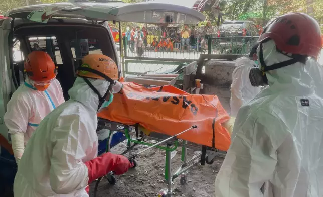 Rescuers disinfect the body bag containing the body of a victim of a collapsed building at an Islamic boarding school in Sidoarjo, East Java, Indonesia, Friday, Oct. 3, 2025. (AP Photo/Trisnadi)
