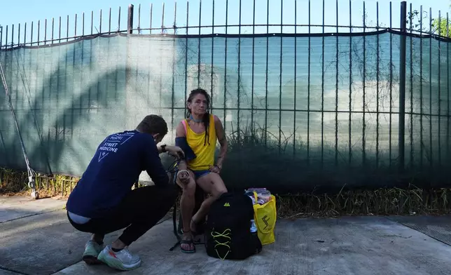 Malachi Peterson-Hester, left, takes the blood pressure of Jeremias Rodriguez Catalina, right, while working with Miami Street Medicine to provide medical services to homeless people, Saturday, Sept. 20, 2025, in Miami. (AP Photo/Lynne Sladky)