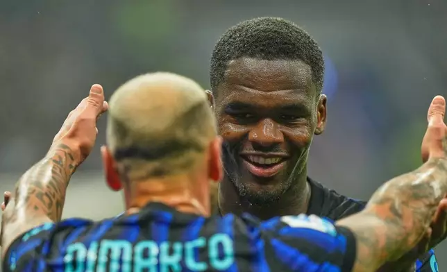 Inter Milan's Ange-Yoan Bonny celebrates with Inter Milan's Federico Dimarco after scoring his side's second goal during the Serie A soccer match between Inter Milan and Cremonese at the San Siro stadium in Milan, Italy, Saturday, Oct. 4, 2025. (AP Photo/Luca Bruno)