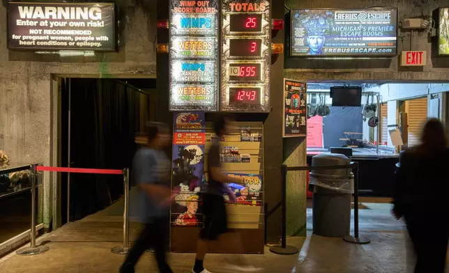 Visitors walk past an electronic "Wimp Board" at the Erebus Haunted House, Oct. 2, 2025, in Pontiac, Mich. (AP Photo/Ryan Sun)