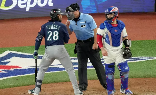 Seattle Mariners third base Eugenio Suárez (28) expresses his anger at the umpire for a called strike during eighth inning MLB American League Championship Series game 7 baseball action against the Toronto Blue Jays, in Toronto, Monday, Oct. 20, 2025. (Chris Young/The Canadian Press via AP)