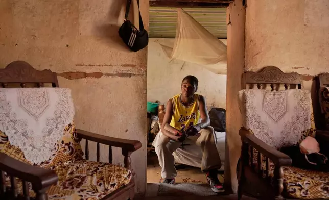 Donah Falia, a 20-year-old student pursuing an accounting course at ABC College, sits inside his aunt's house in Anosimahavelona informal settlement in Antananarivo, Madagascar, Thursday, Oct. 16, 2025. (AP Photo/Brian Inganga)