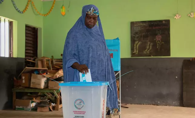 A woman casts her ballot at a polling station during the presidential election in Garoua, Cameroon, Sunday, Oct. 12, 2025. (AP Photo/Welba Yamo Pascal)