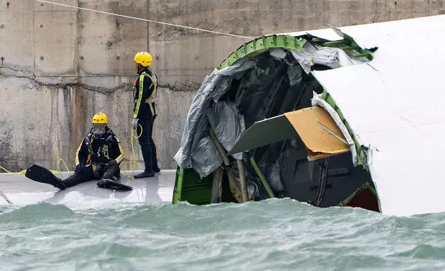 A diver prepares to inspect the cargo aircraft that skidded off a Hong Kong runway on Monday, Oct. 20, 2025. (AP Photo/Chan Long Hei)