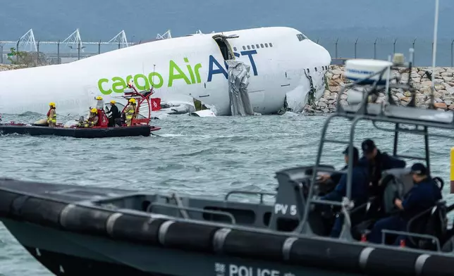 Rescue workers approach a cargo aircraft that skidded off a Hong Kong runway on Monday, Oct. 20, 2025. (AP Photo/Chan Long Hei)